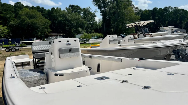 Slide: The Image of 2025 Carolina Skiff 19 LS Stealth Edition boat on display, surrounded by trees and other boats. - 10