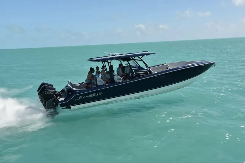 Slide: The Image of 2026 Nor-Tech 390 Sport Center Console boat on trailer with powerful outboard engines. - 2