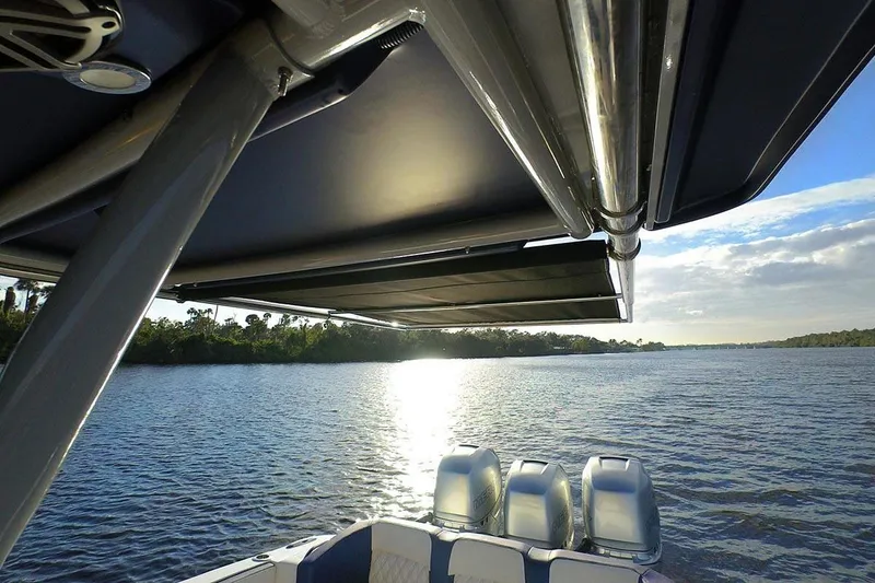 Slide: The Image of 2026 Nor-Tech 390 Sport Center Console boat interior with seating and deck, under a bright sky. - 20