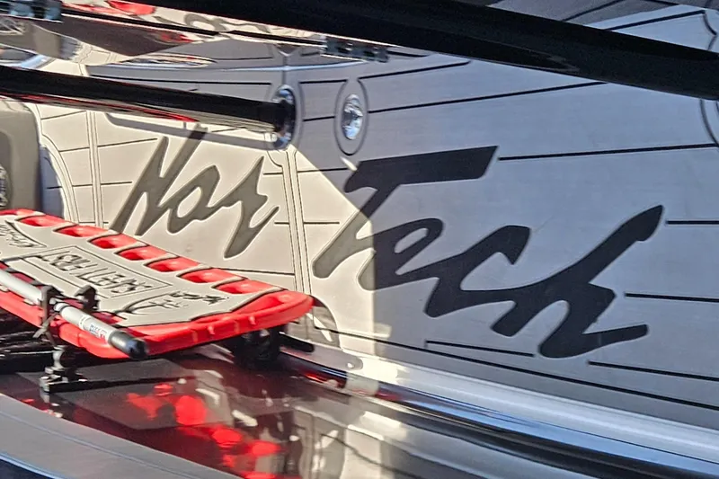 Slide: The Image of 2026 Nor-Tech 390 Sport Center Console boat with powerful outboard engines in a showroom. - 8