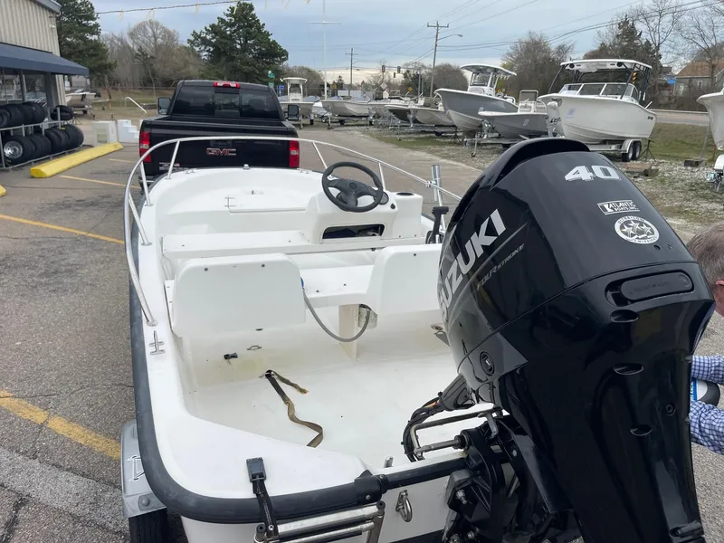 Slide: The Image of 2005 Boston Whaler 150 Sport with Suzuki 40 HP engine, parked near other boats. - 4