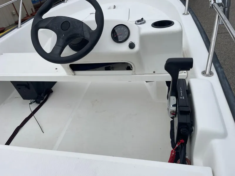 Slide: The Image of 2005 Boston Whaler 150 Sport boat interior with steering wheel and control panel. - 8