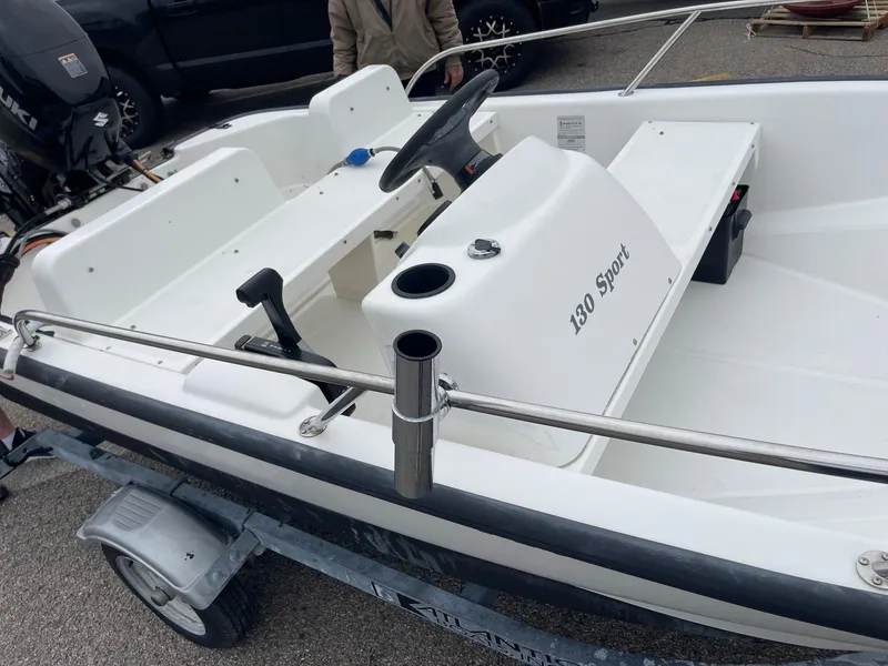 Slide: The Image of 2005 Boston Whaler 150 Sport boat on trailer, white interior, steering console visible. - 9