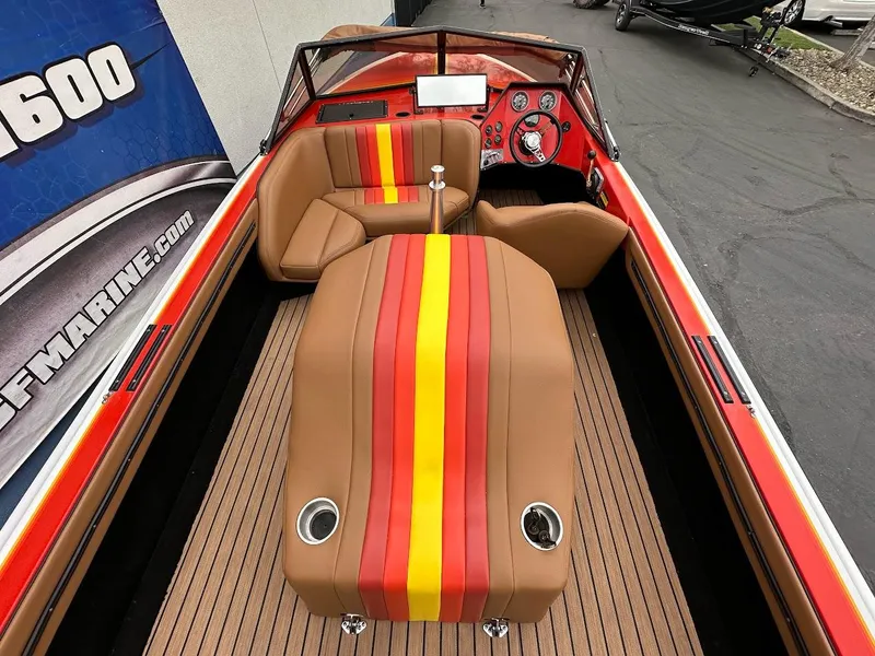 Slide: The Image of 1988 Malibu Skier boat interior with red and yellow striped upholstery, wooden flooring, and dashboard controls. - 10