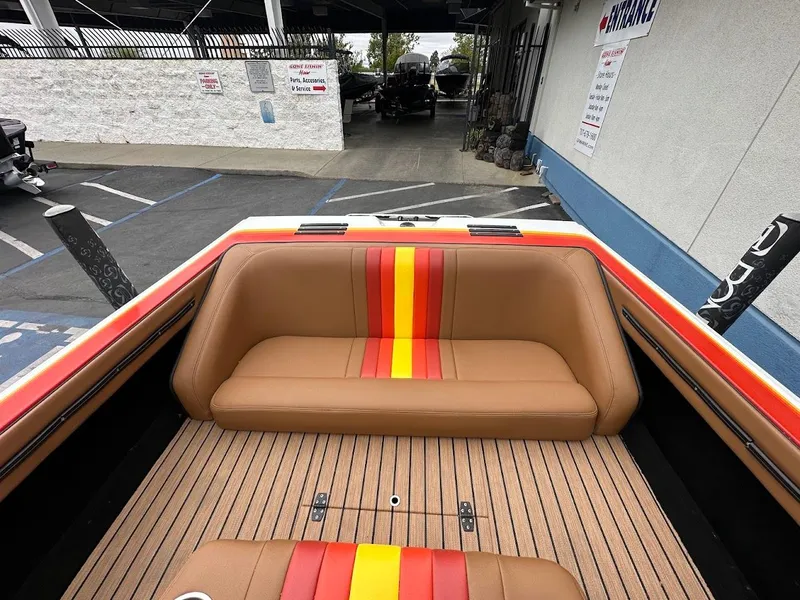 Slide: The Image of 1988 Malibu Skier boat interior with brown seating and vibrant red-yellow stripes. - 13