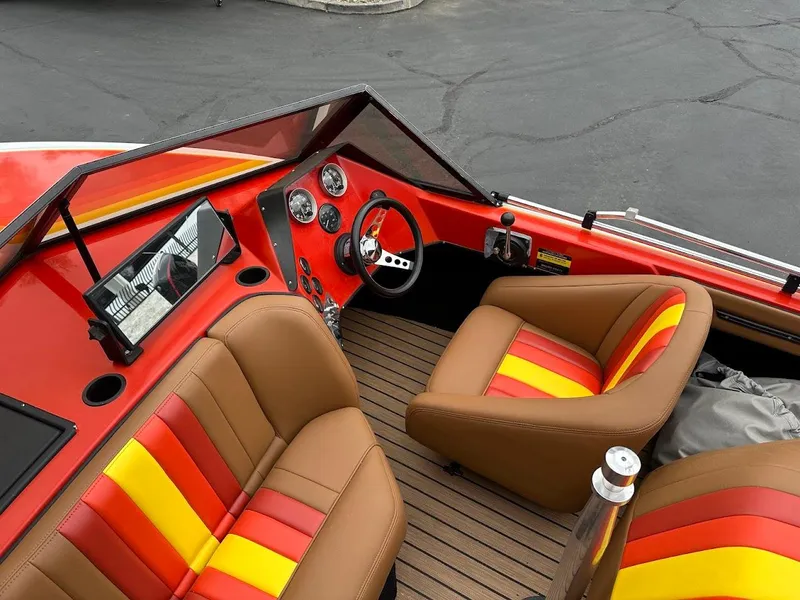 Slide: The Image of 1988 Malibu Skier boat interior with vibrant red, yellow, and brown seating, and classic dashboard. - 14