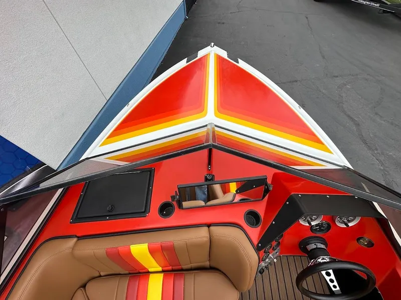 Slide: The Image of 1988 Malibu Skier boat interior with vibrant red and yellow design, brown seating, and dashboard controls. - 19