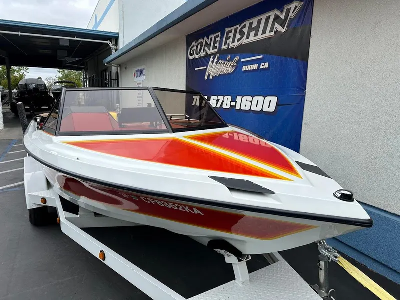 Slide: The Image of 1988 Malibu Skier boat with vibrant red and yellow design on a trailer. - 4