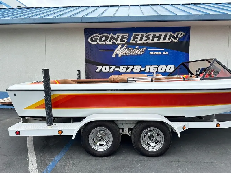Slide: The Image of 1988 Malibu Skier boat on trailer, parked outside a building with "Gone Fishin'" sign. - 6