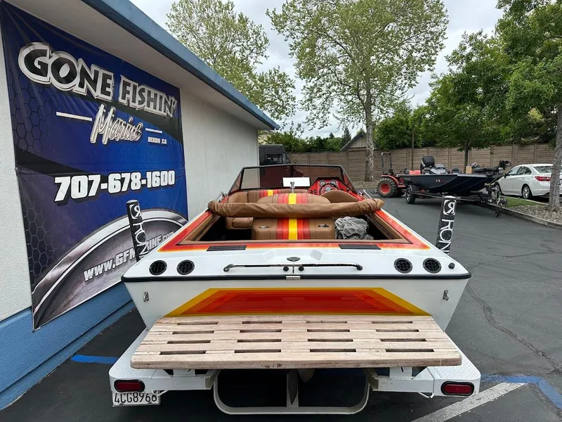 Slide: The Image of 1988 Malibu Skier boat parked near a fishing shop, showcasing vibrant retro design. - 8