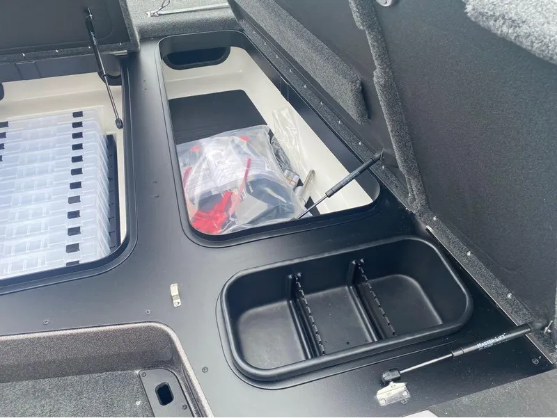 Slide: The Image of Storage compartments in a 2025 Skeeter ZXR 21 boat, featuring organized tackle boxes. - 19