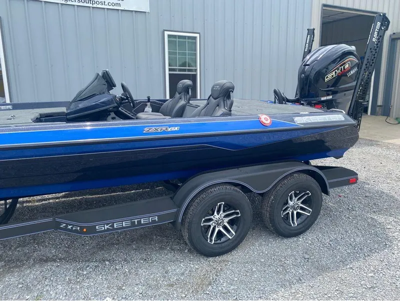 Slide: The Image of 2025 Skeeter ZXR 21 boat with Yamaha engine, parked on gravel near a building. - 3
