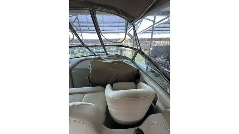 Slide: The Image of 2002 Sea Ray 340 Sundancer boat interior with white seating and covered dashboard. - 18