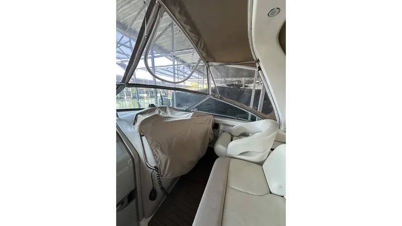 Slide: The Image of 2002 Sea Ray 340 Sundancer cockpit with covered controls and seating under canopy. - 20