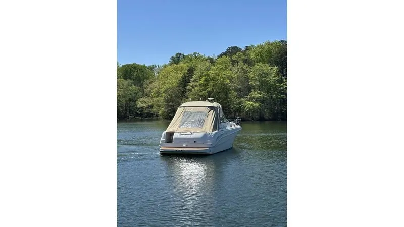 Slide: The Image of 2002 Sea Ray 340 Sundancer boat on a calm lake with lush green trees. - 3
