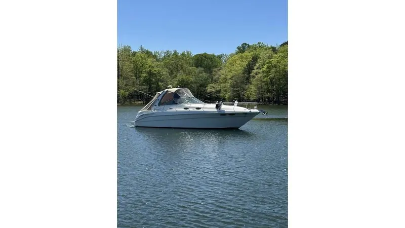 Slide: The Image of 2002 Sea Ray 340 Sundancer boat on a calm lake with trees in the background. - 4