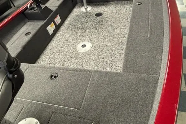 Slide: The Image of 2025 Tracker Super Guide V-16 T boat interior with gray carpet and storage compartments. - 2