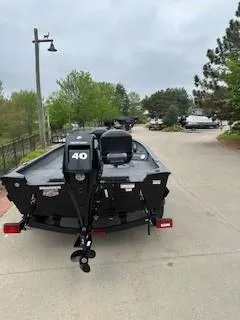 Slide: The Image of 2025 Tracker Super Guide V-16 T boat on a trailer, parked outdoors. - 2