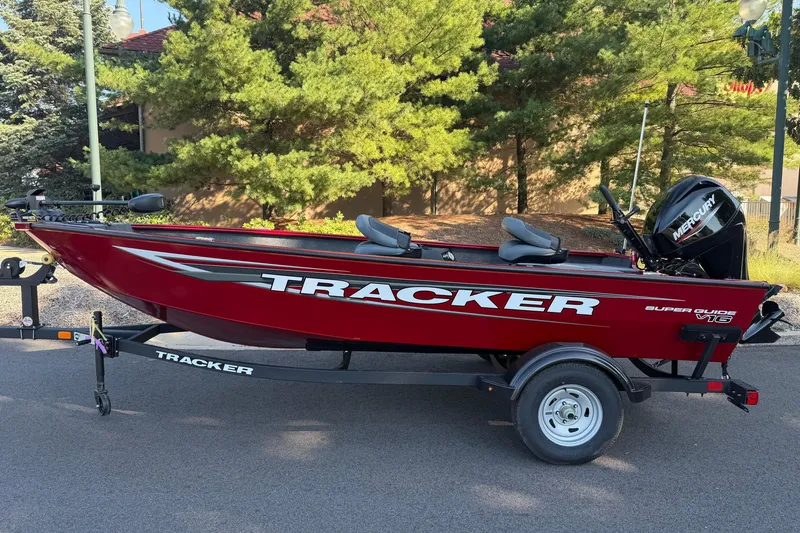 The Image of 2025 Tracker Super Guide V-16 T boat on trailer, parked outdoors. - 0