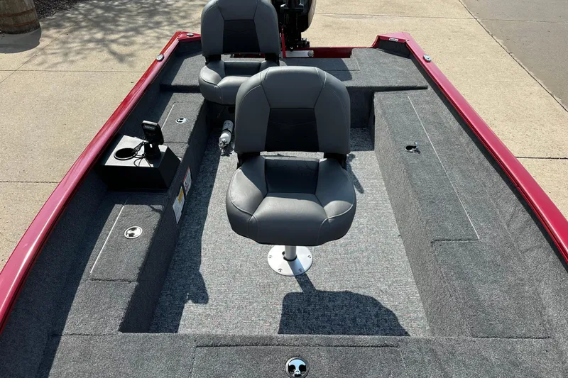 Slide: The Image of 2025 Tracker Super Guide V-16 T boat interior with gray seating and red trim. - 2