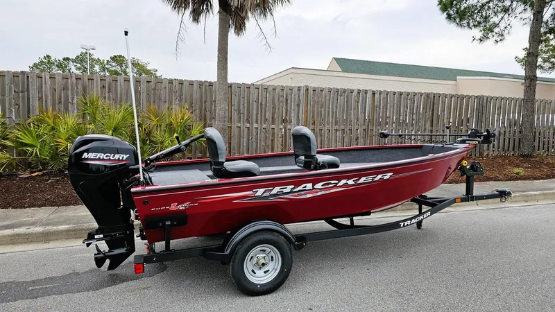 The Image of 2025 Tracker Super Guide V-16 T boat with Mercury engine on trailer, parked outdoors. - 0