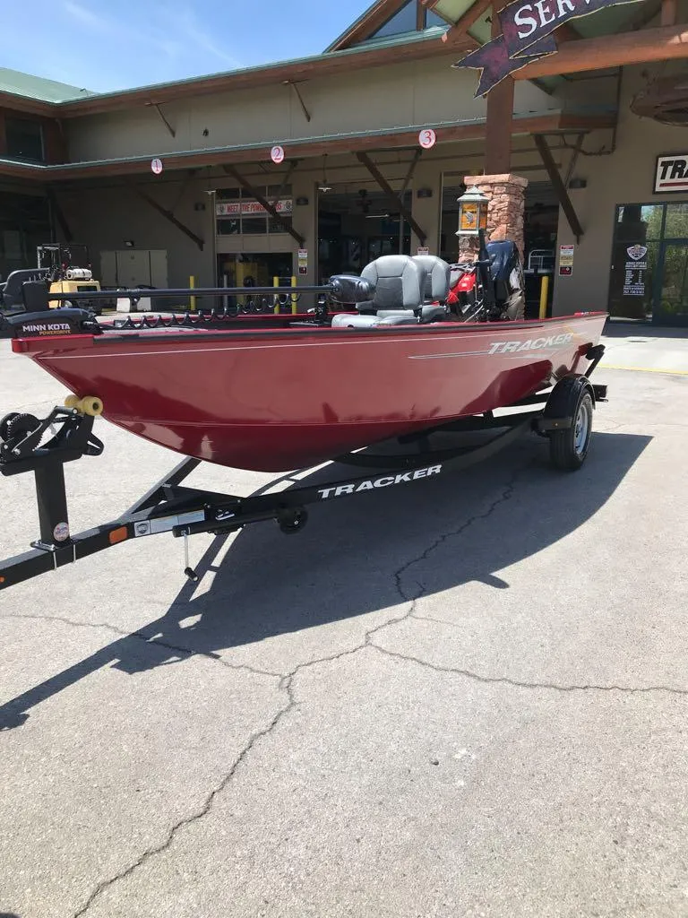 Slide: The Image of 2025 Tracker Super Guide V-16 T boat on trailer, parked outside a service center. - 2