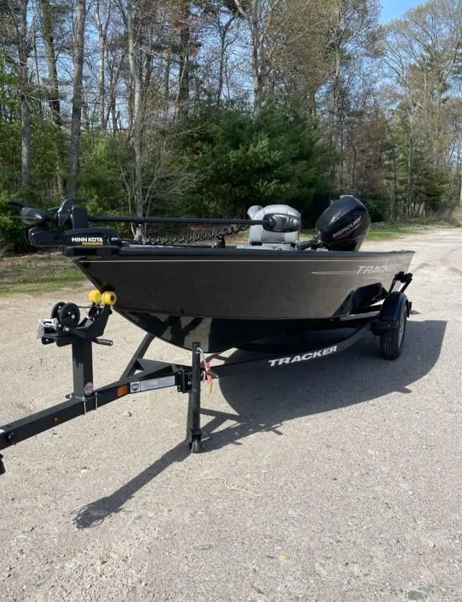 Slide: The Image of 2025 Tracker Super Guide V-16 T boat on trailer in wooded area. - 2