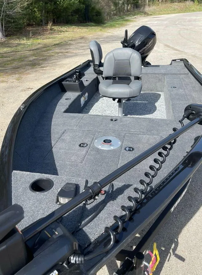 Slide: The Image of 2025 Tracker Super Guide V-16 T fishing boat with seating and motor, parked on a sunny day. - 3