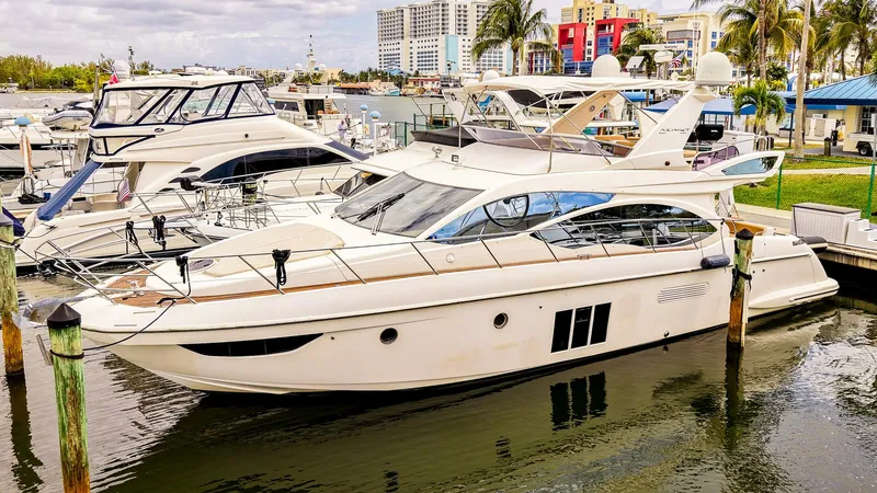 Slide: The Image of Azimut Fly 53 yacht docked in a marina, showcasing sleek design and wooden deck. - 0