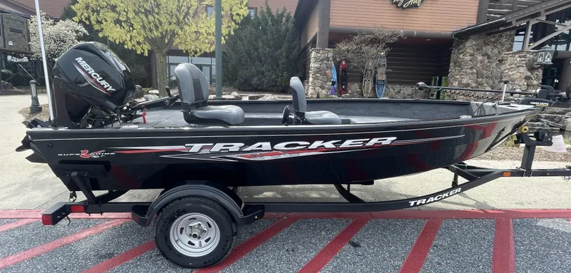 The Image of 2025 Tracker Super Guide V-16 T boat on trailer, parked outdoors. - 0