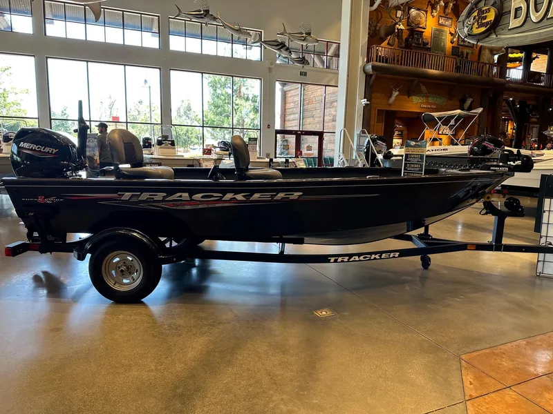 Slide: The Image of 2025 Tracker Super Guide V-16 T boat displayed indoors with Mercury engine. - 2