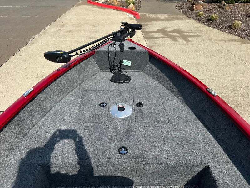 Slide: The Image of 2025 Tracker Super Guide V-16 T boat deck with trolling motor, red trim, and gray carpet. - 3