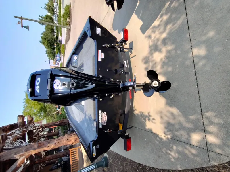 Slide: The Image of 2025 Tracker Super Guide V-16 T boat with 40 HP motor, parked on concrete. - 33