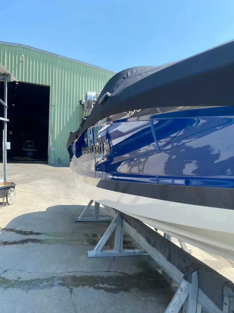 Slide: The Image of 2021 MasterCraft X24 boat on stands outside a green warehouse. - 10
