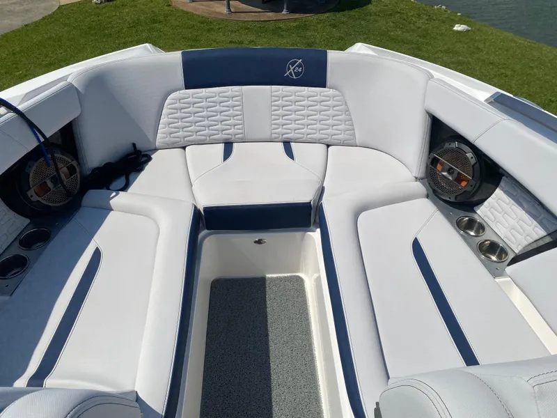 Slide: The Image of 2021 MasterCraft X24 boat interior with white and blue cushioned seating. - 13