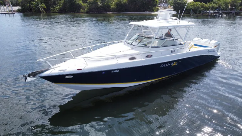 Slide: The Image of 2006 Donzi 38 ZSF boat on calm water, featuring sleek design and white-blue color scheme. - 12