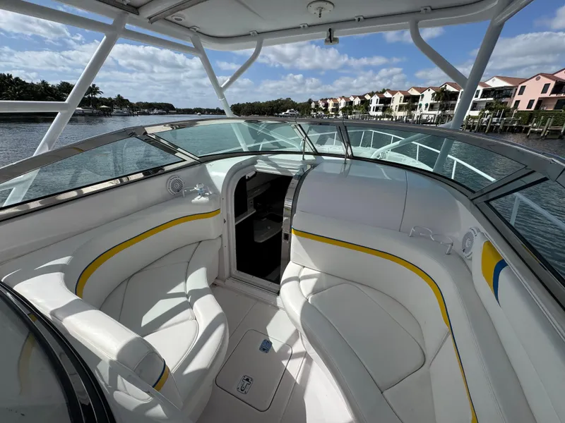 Slide: The Image of 2006 Donzi 38 ZSF boat interior with white seating, yellow accents, and waterfront view. - 18
