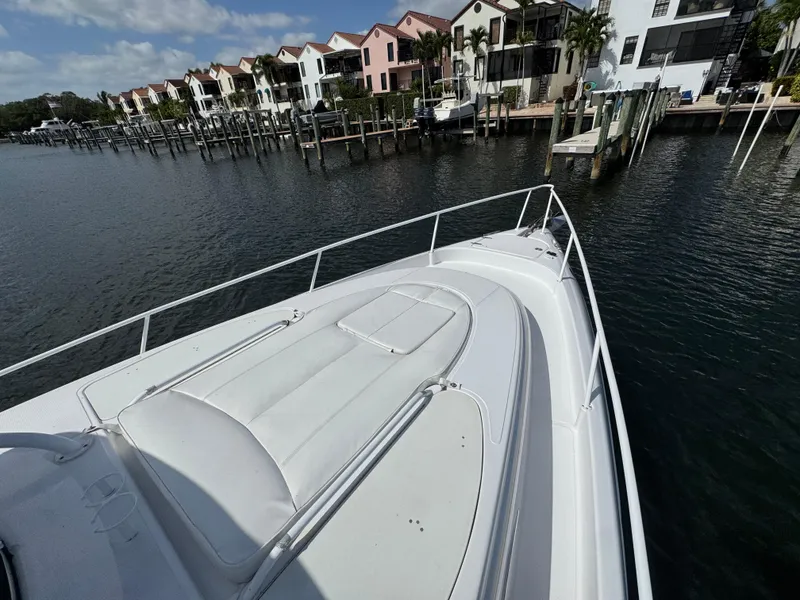 Slide: The Image of 2006 Donzi 38 ZSF boat docked near waterfront homes under a partly cloudy sky. - 19