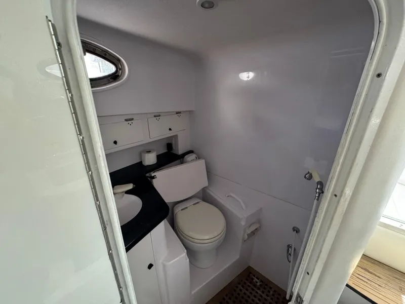 Slide: The Image of 2006 Donzi 38 ZSF boat bathroom with toilet, sink, and storage cabinets. - 25