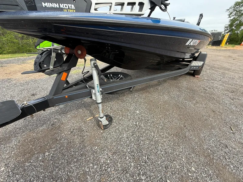 Slide: The Image of 2023 Skeeter ZXR20 boat on trailer with Minn Kota motor, parked on gravel. - 1