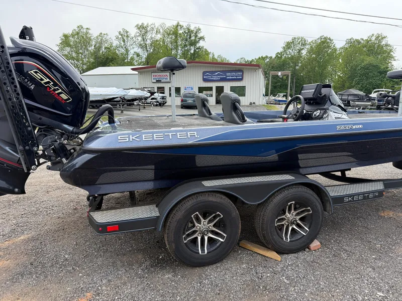 Slide: The Image of 2023 Skeeter ZXR20 boat on trailer, parked outdoors near dealership. - 10