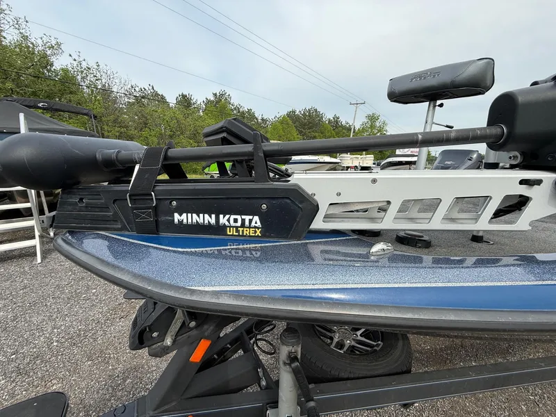Slide: The Image of 2023 Skeeter ZXR20 boat with Minn Kota Ultrex trolling motor, parked outdoors. - 2