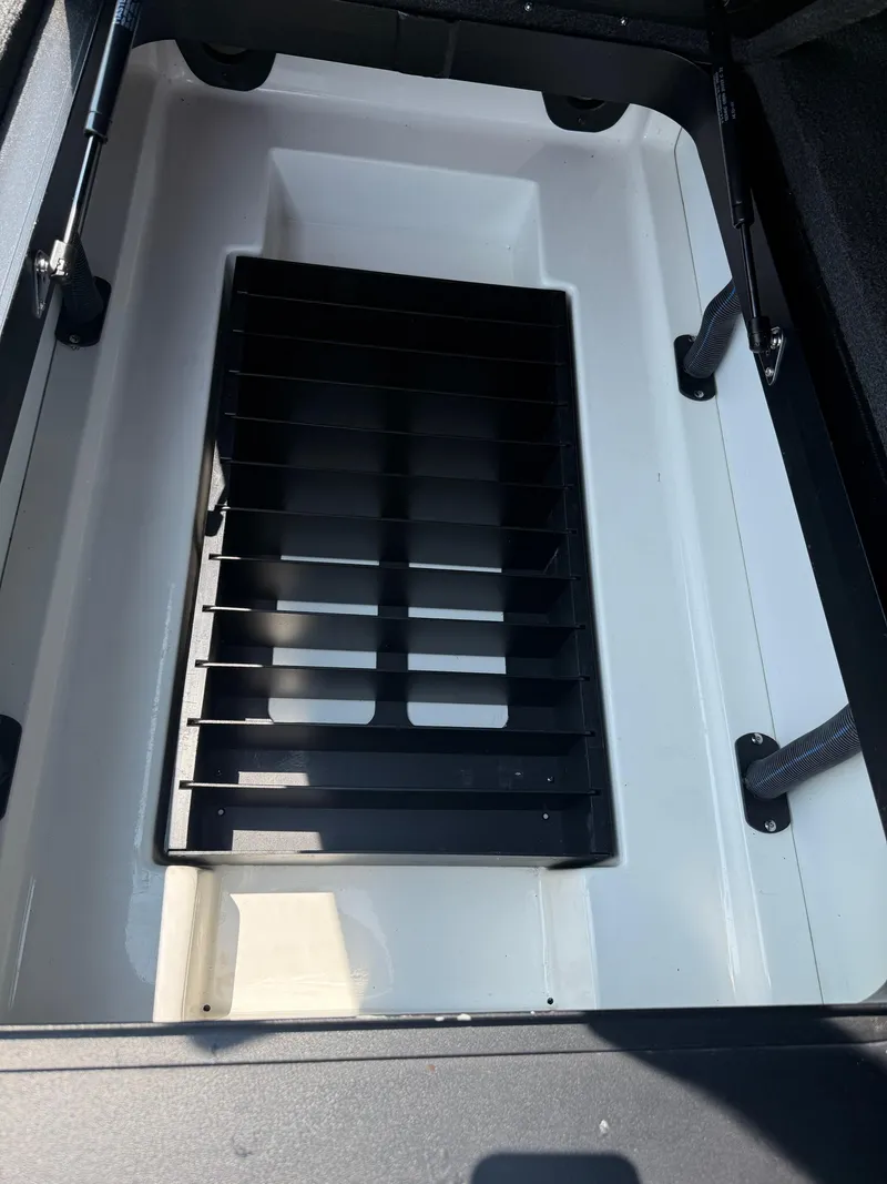 Slide: The Image of 2023 Skeeter ZXR20 boat storage compartment with black divider. - 20