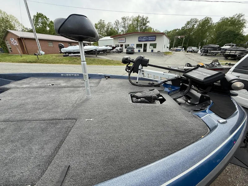 Slide: The Image of 2023 Skeeter ZXR20 boat deck with seat and control panel, parked outdoors. - 8