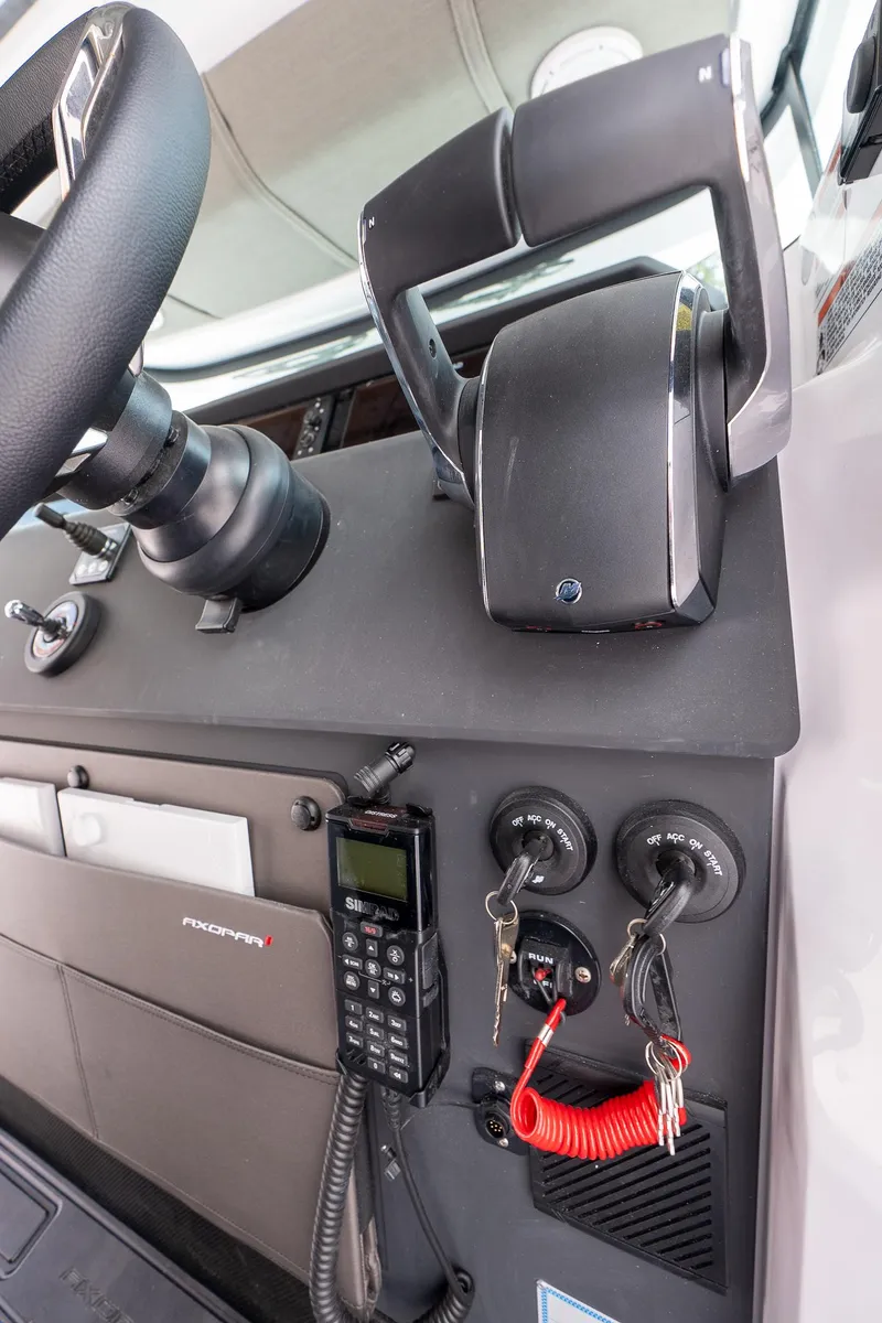 Slide: The Image of 2024 Axopar Cross Cabin dashboard with steering wheel, controls, and communication equipment. - 26