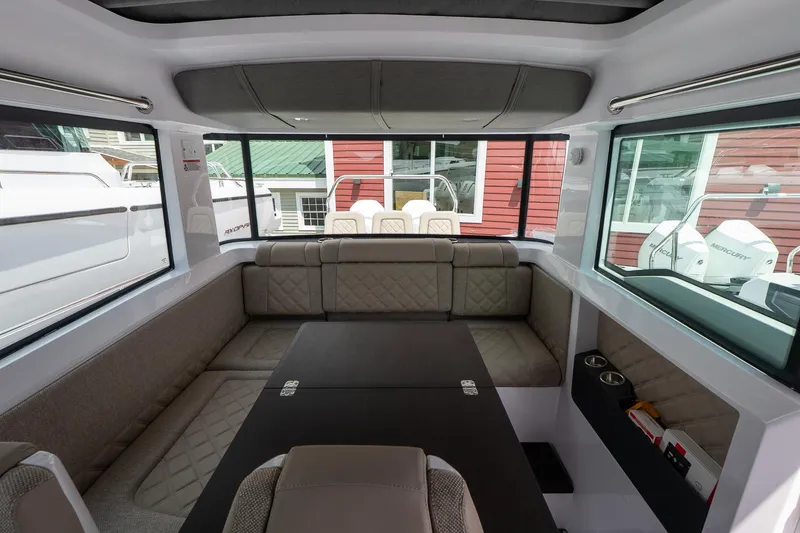 Slide: The Image of 2024 Axopar Cross Cabin interior with modern seating and panoramic windows. - 33