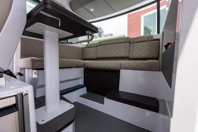 Slide: The Image of 2024 Axopar Cross Cabin interior with modern seating and table setup. - 34