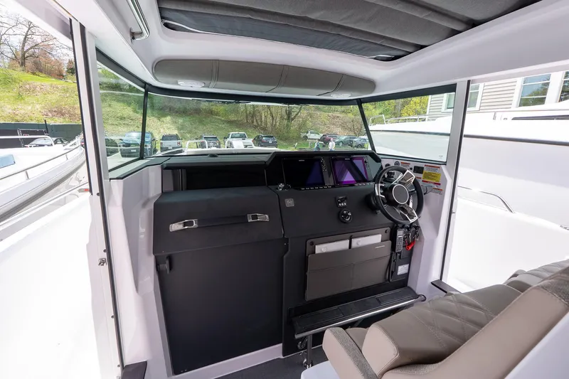 Slide: The Image of 2024 Axopar Cross Cabin interior with modern dashboard and steering wheel. - 38