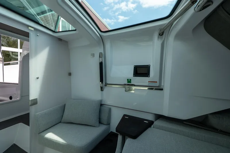 Slide: The Image of 2024 Axopar Cross Cabin interior with skylight, modern seating, and sleek design. - 45