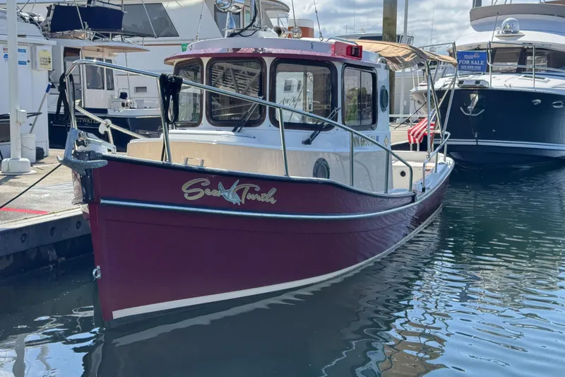 Slide: The Image of 2016 Ranger Tugs R-21EC boat docked in marina, red hull, classic design. - 1